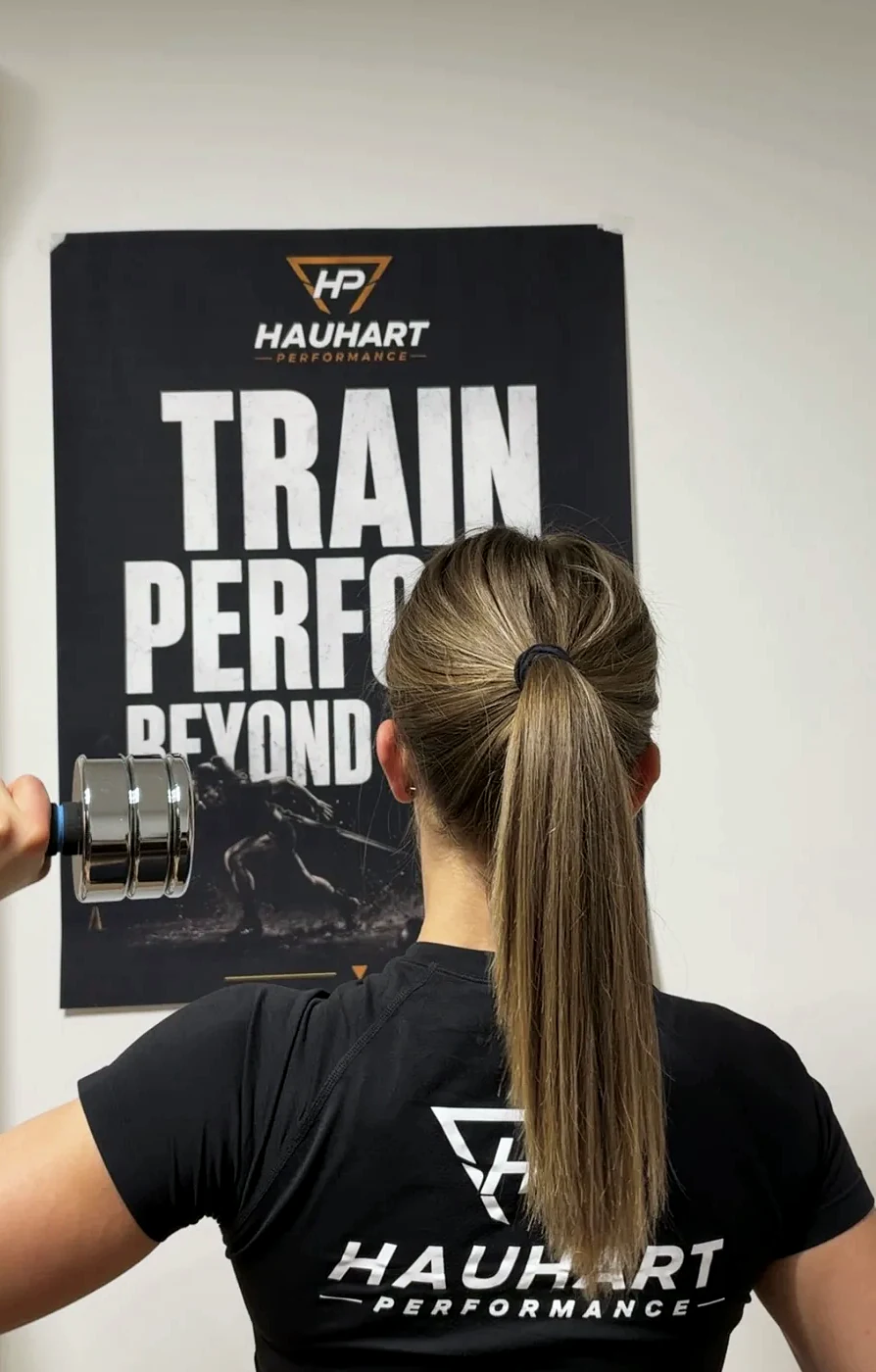 Johanna Hauhart beim Hanteltraining, Rückenansicht mit Logo